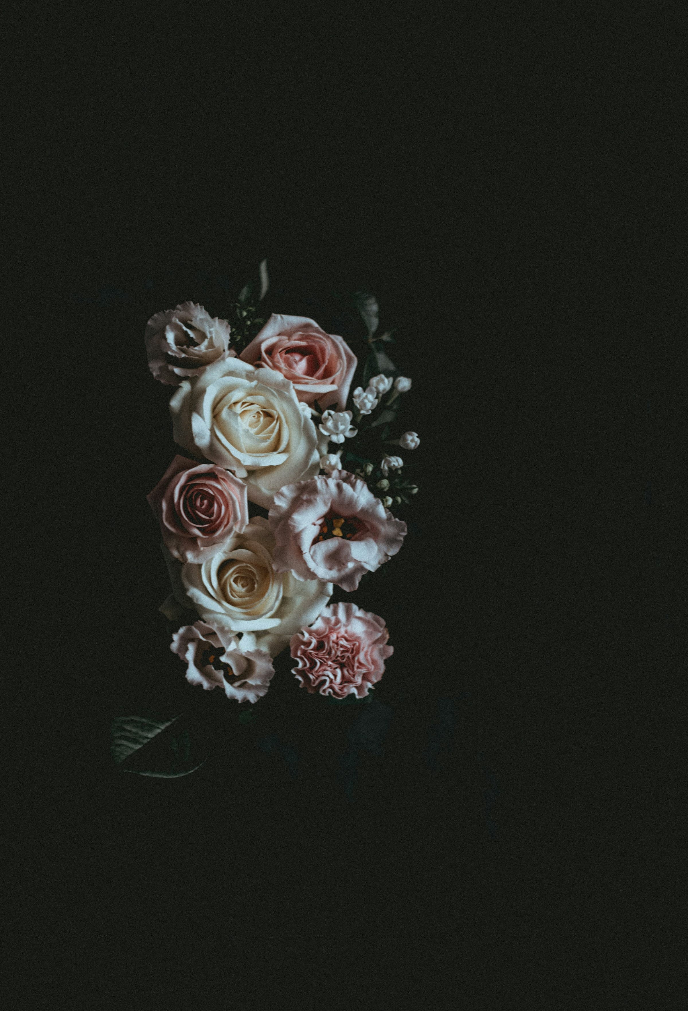 A loose hand-tied bouquet of pink and white garden flowers in soft natural light